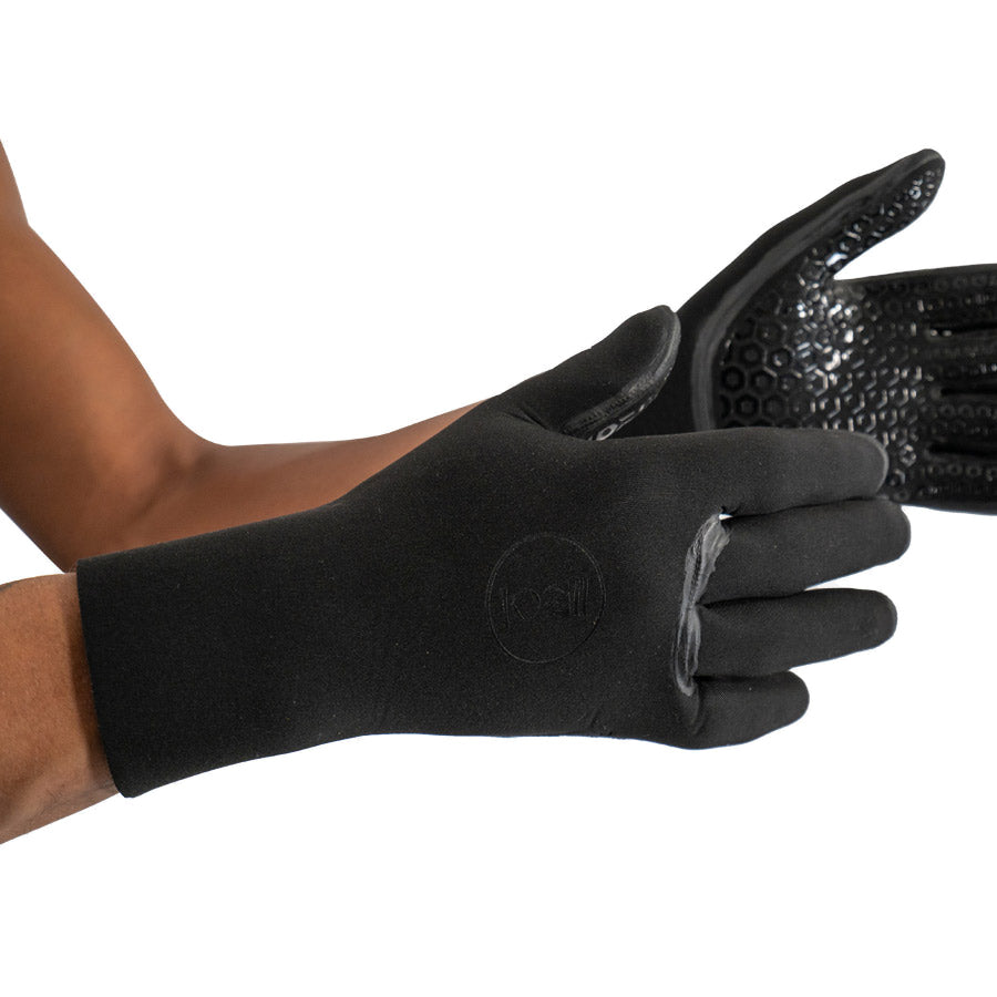 Pair of black Fourth Element 3mm neoprene dive gloves worn on the hands, one turned to show the textured grip palm