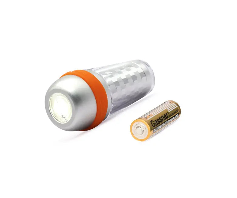 OrcaTorch SD03 beacon lying beside the AA cell it takes