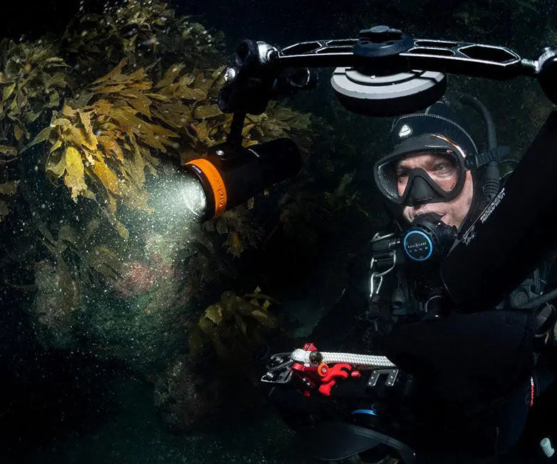 Diver underwater holding an OrcaTorch D910V video light