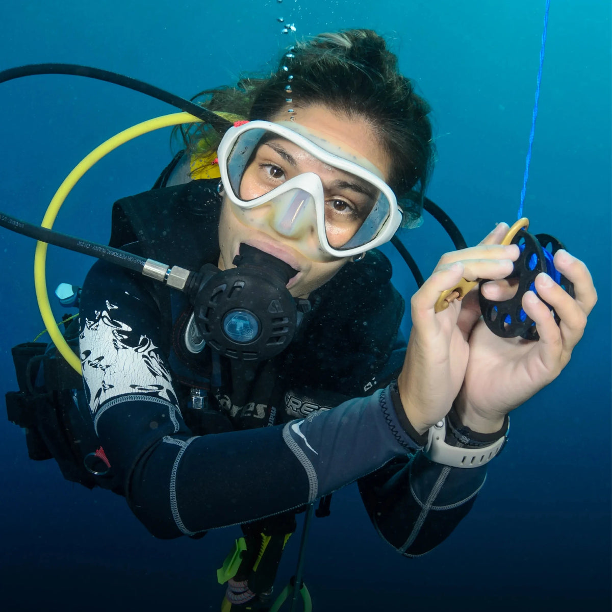 A diver signalling underwater while holding a line