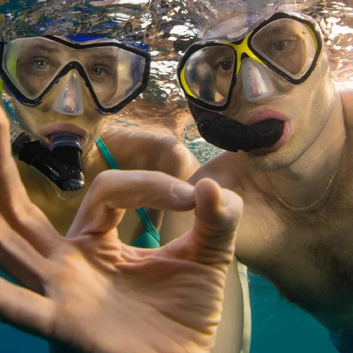 Two snorkellers at the surface giving the OK signal