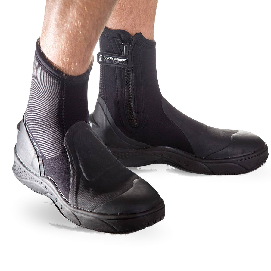 Pair of black Fourth Element Amphibian 6.5mm dive boots worn, showing the side zip and moulded rubber sole