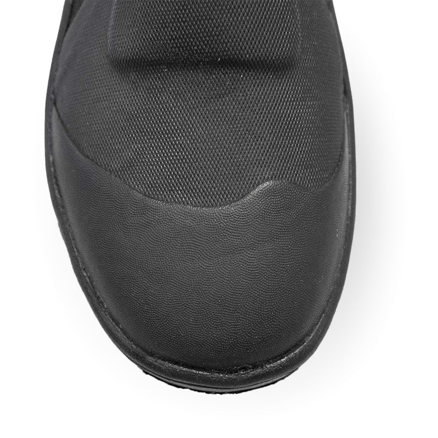 Pair of black Fourth Element Amphibian 6.5mm dive boots worn, showing the side zip and moulded rubber sole
