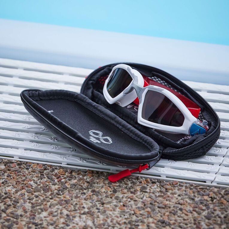 White swim goggles stored inside the open Aquasphere goggle case by a pool