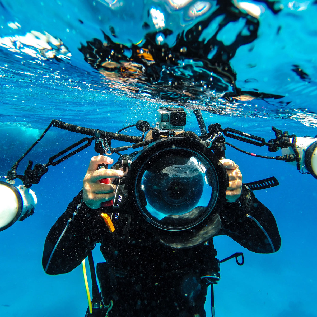 Underwater photographer with a camera housing, dome port and strobes