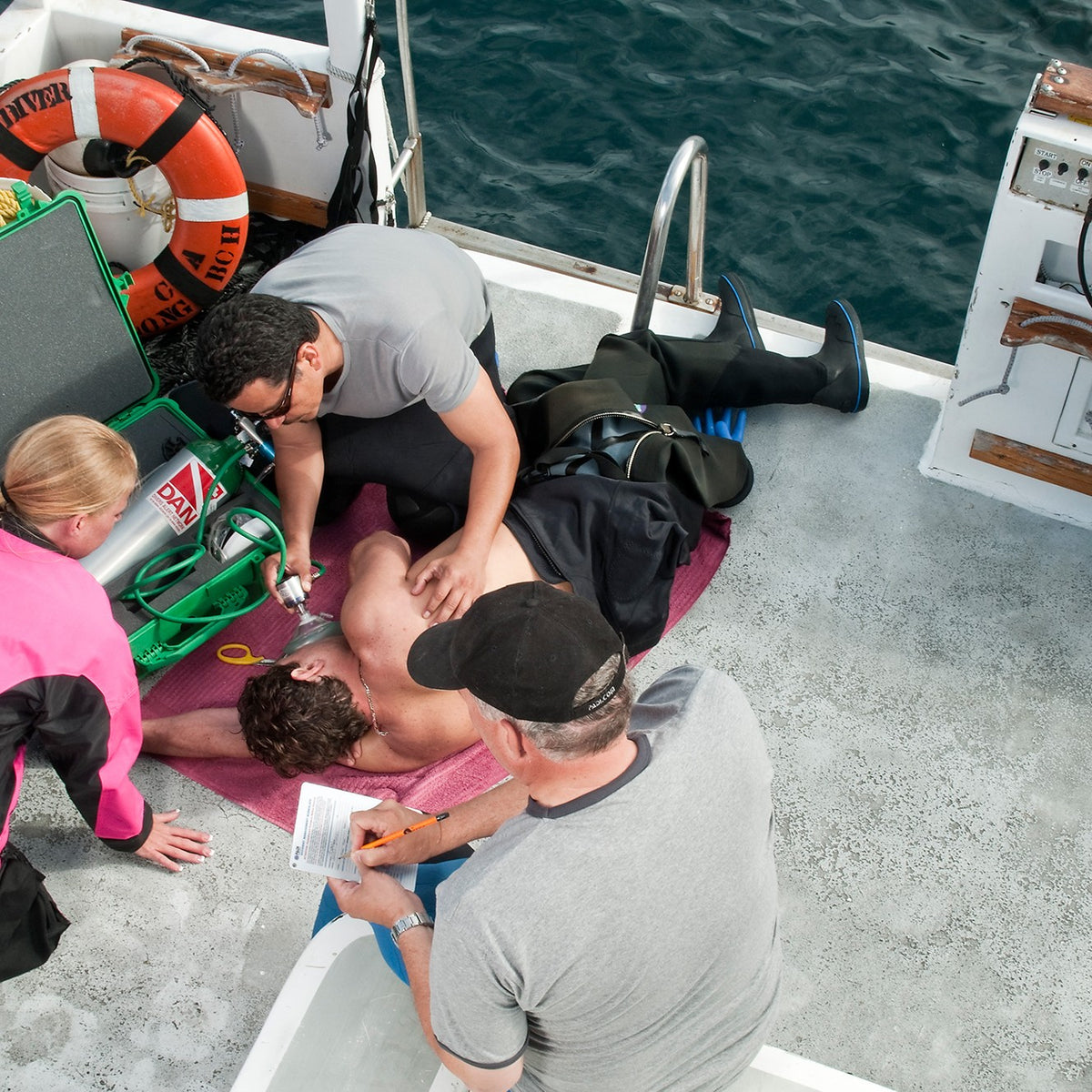 Emergency oxygen being given to a diver on a boat deck during a training scenario