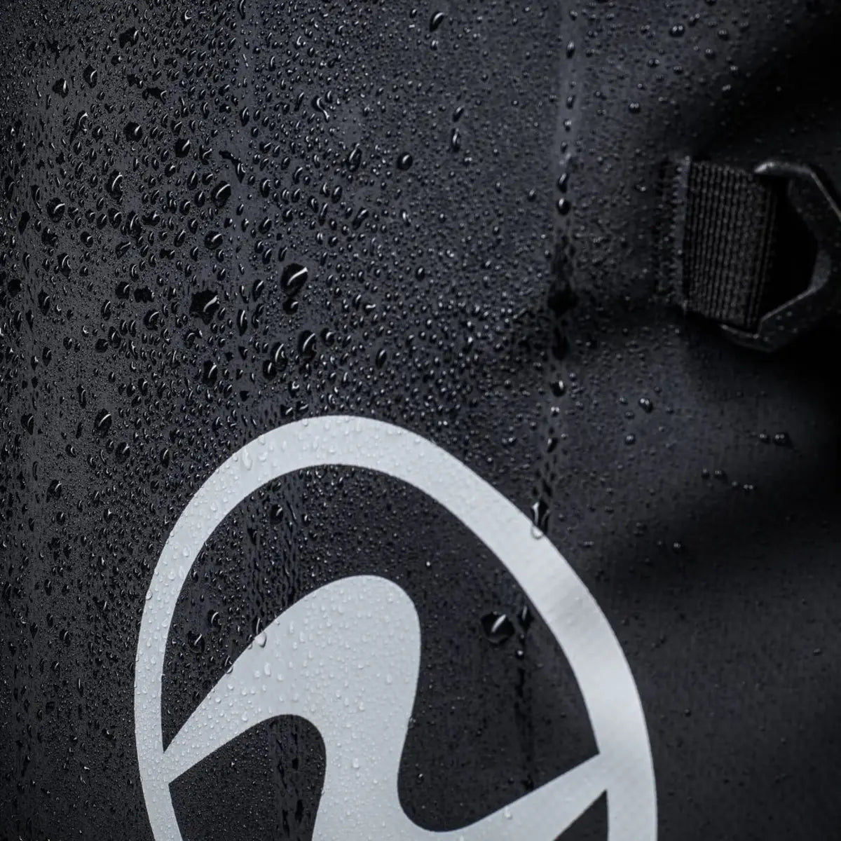 Close-up of the water-repellent outer fabric on an Aqua Lung Explorer 120L dive bag, with water beading beside the logo
