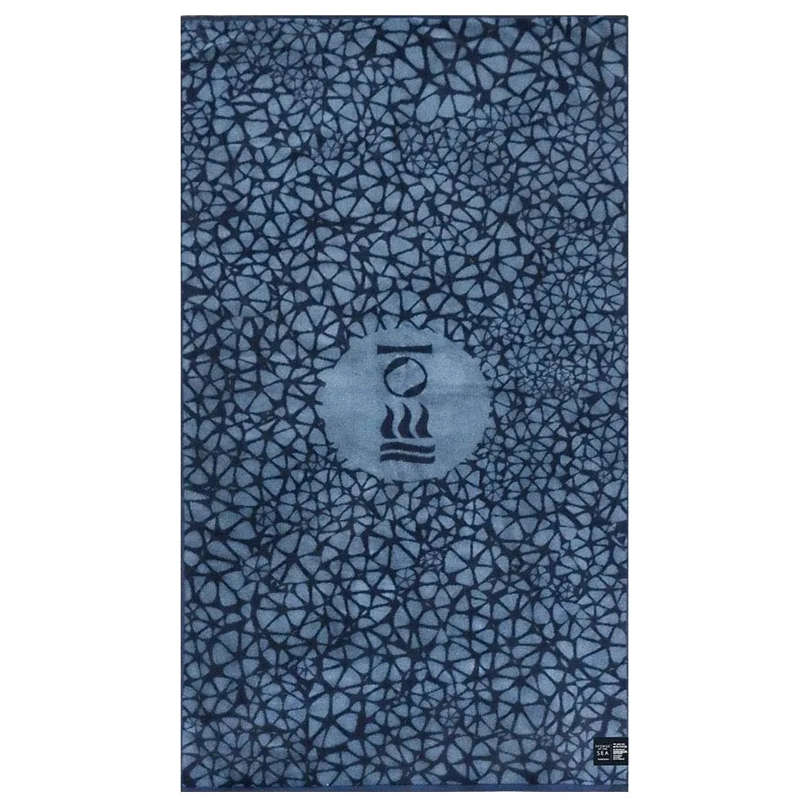 Fourth Element OceanPositive beach towel laid flat, showing the blue cell print and centre logo