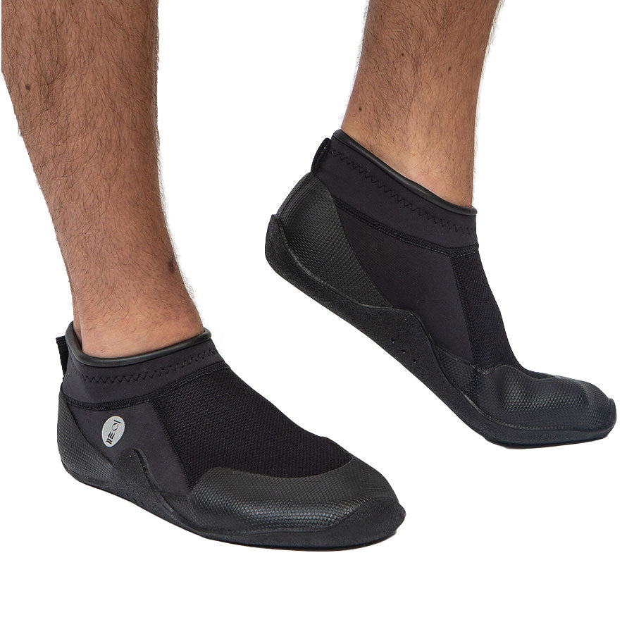 Pair of black Fourth Element Rock Hopper 3mm low-cut boots worn on the feet