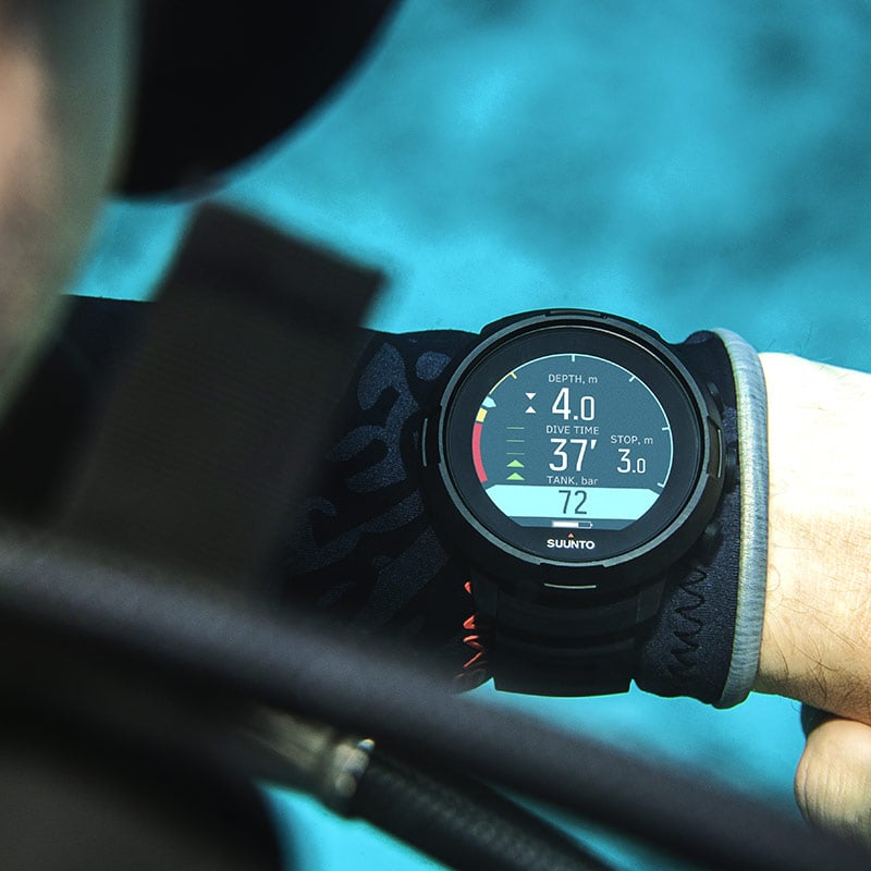 Suunto D5 worn over a wetsuit glove underwater, showing depth and dive time