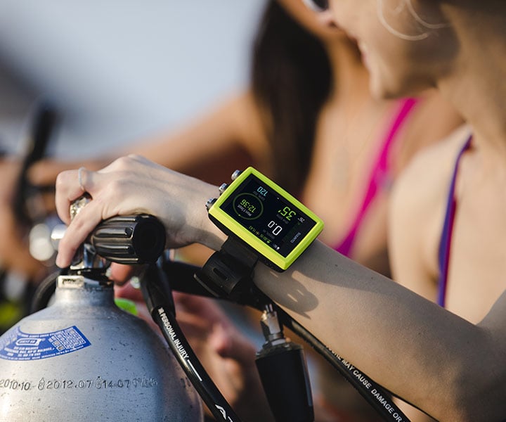 Suunto EON Core in lime being handled at the surface
