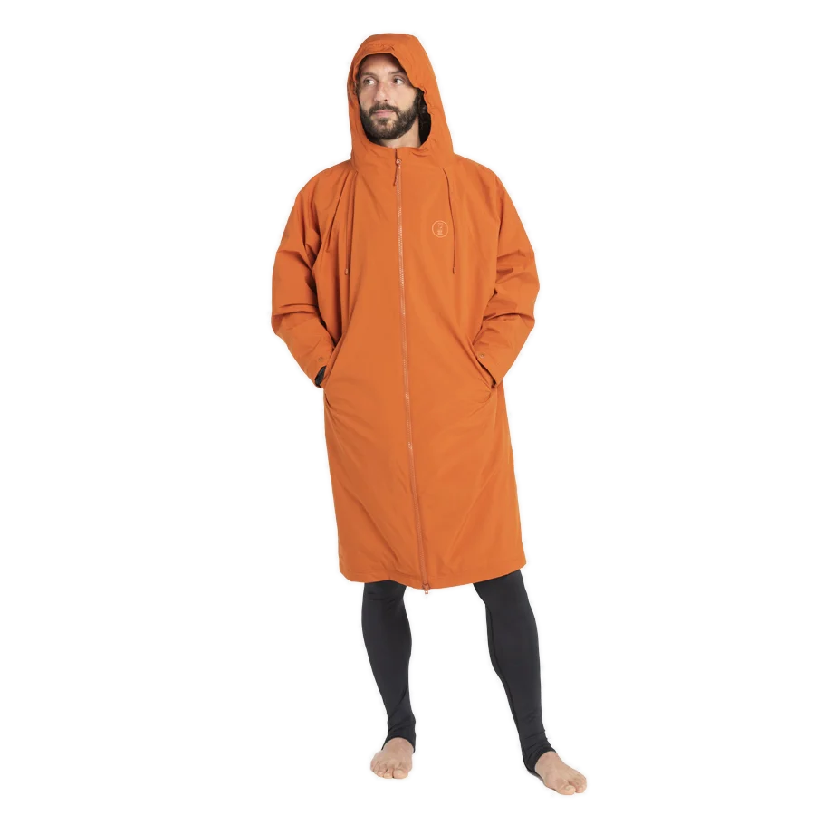Fourth Element Tidal robe in orange worn with the hood up and the front zipped