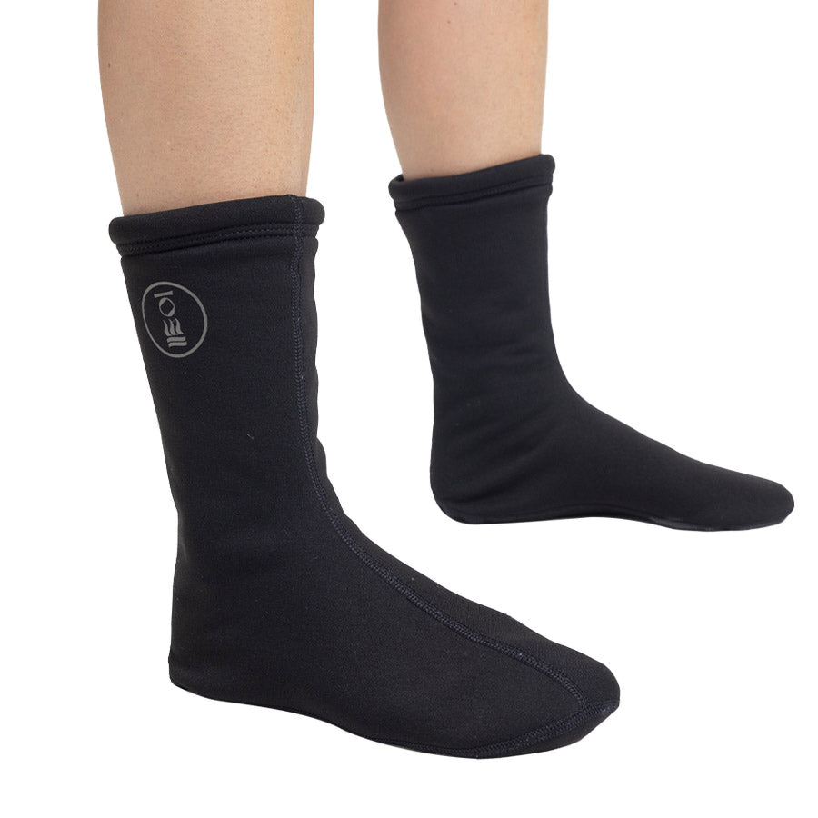 Pair of black Fourth Element Arctic drysuit socks worn on the feet