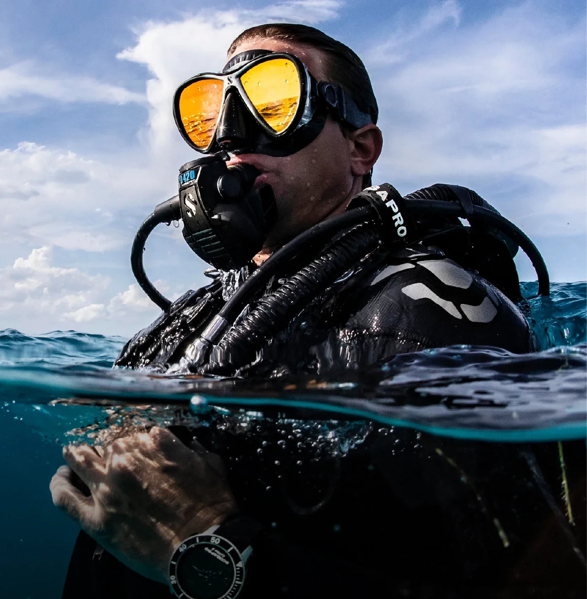 A diver at the surface in full kit against a blue sky