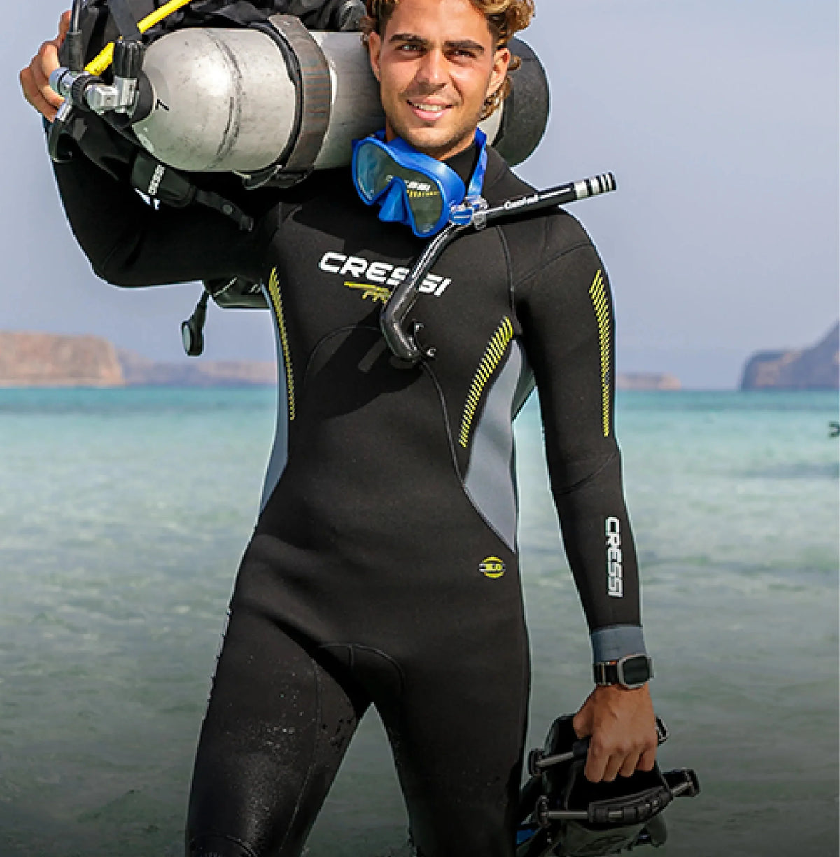 A diver carrying a cylinder and BCD on a beach