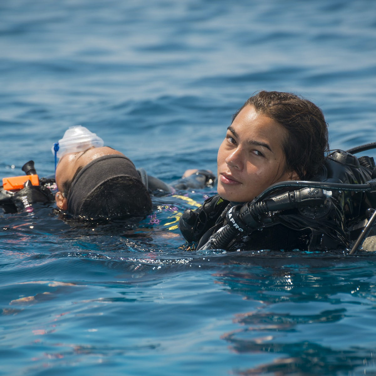 Diver towing an unresponsive diver at the surface during a rescue exercise