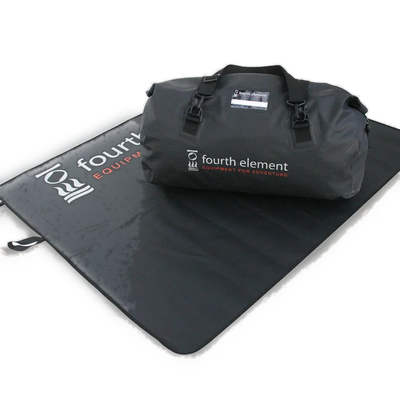 Fourth Element changing mat opened out on the ground with a kit duffel standing on it