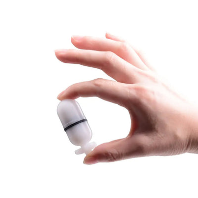 OrcaTorch Torpedo marker light held between finger and thumb, showing its size