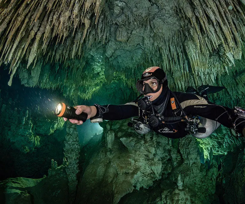 Diver lighting a cavern passage with an OrcaTorch D900V