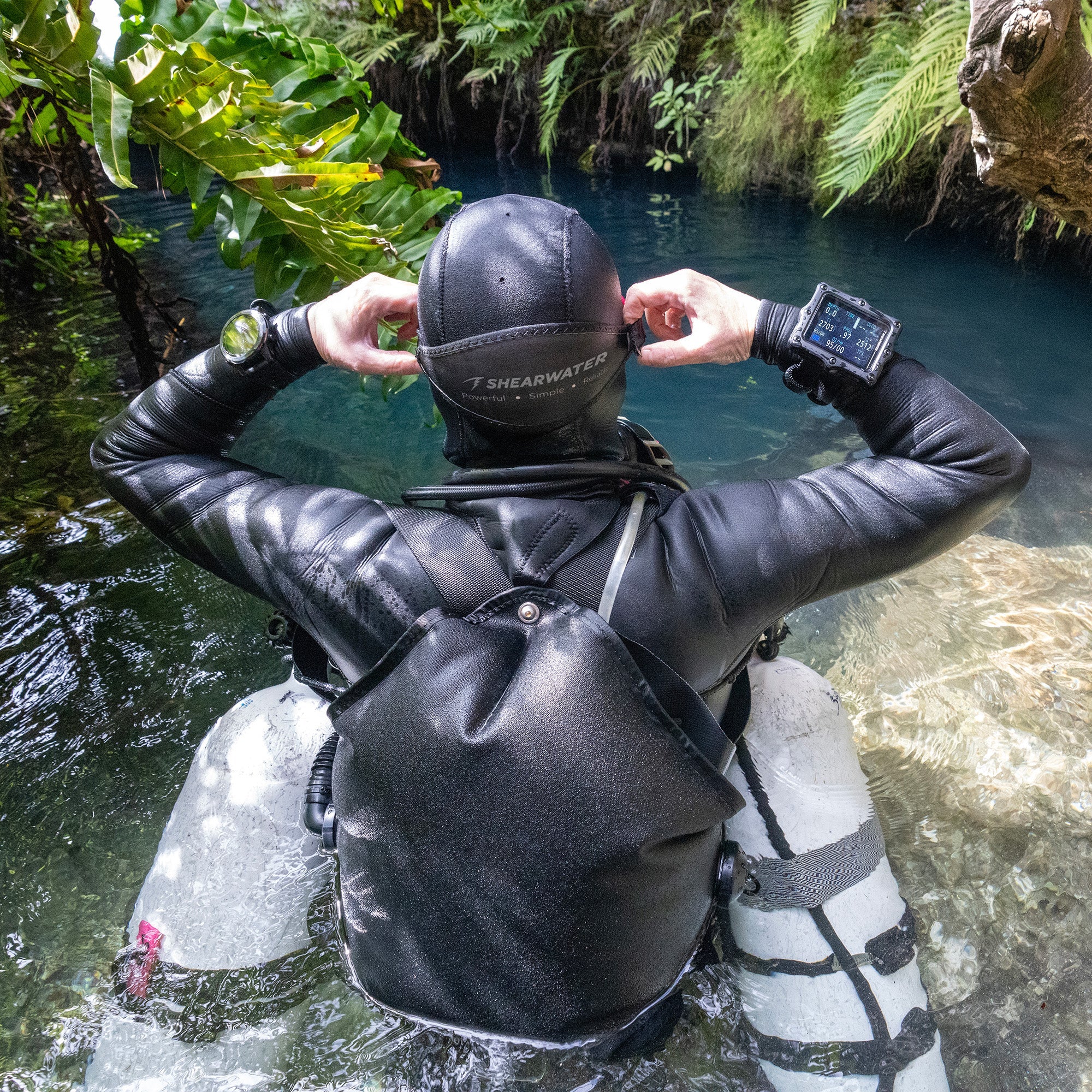 Shearwater Perdix 3 dive computer held at a cave entrance before a technical dive