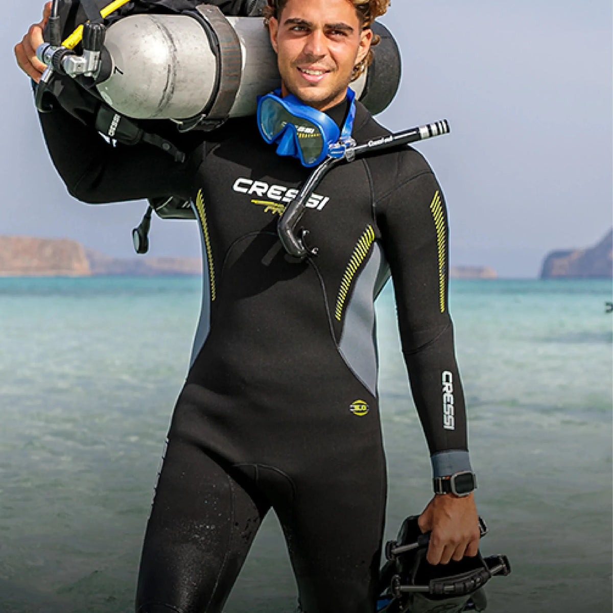 A diver carrying a cylinder and BCD on a beach