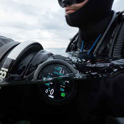 Diver in a hood and mask wearing a black Shearwater Tern TX