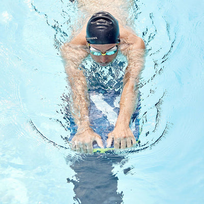 Swimmer in a pool doing a kick set holding the Aquasphere kickboard