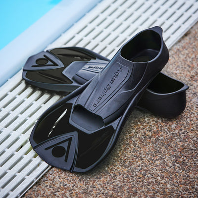 Pair of black Microfin swim training fins on a pool deck grating