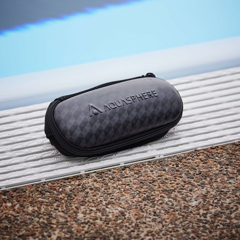 Closed Aquasphere goggle case sitting on a pool deck grating