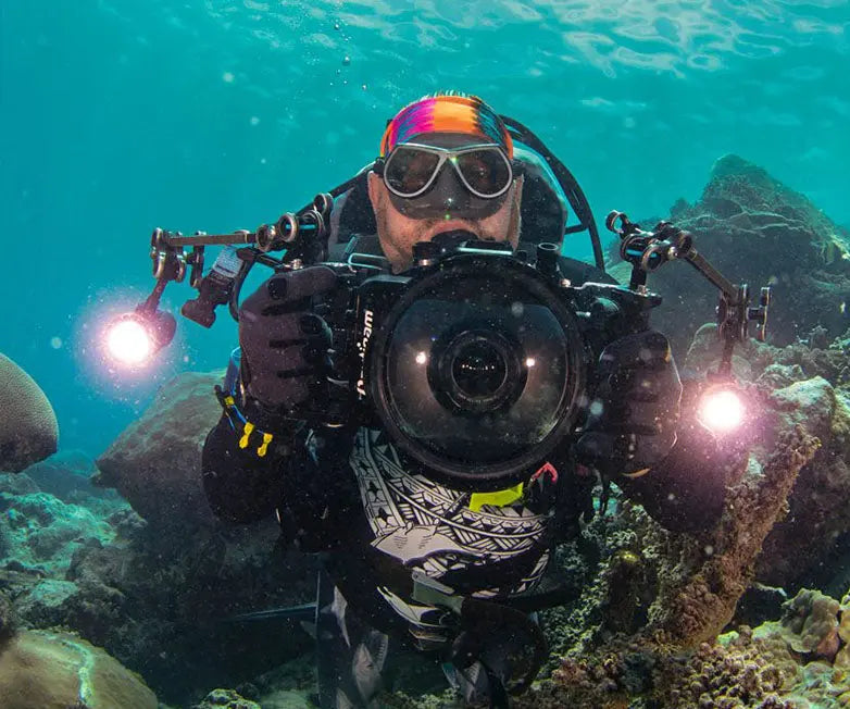 Diver with a camera rig carrying two OrcaTorch D900V video lights