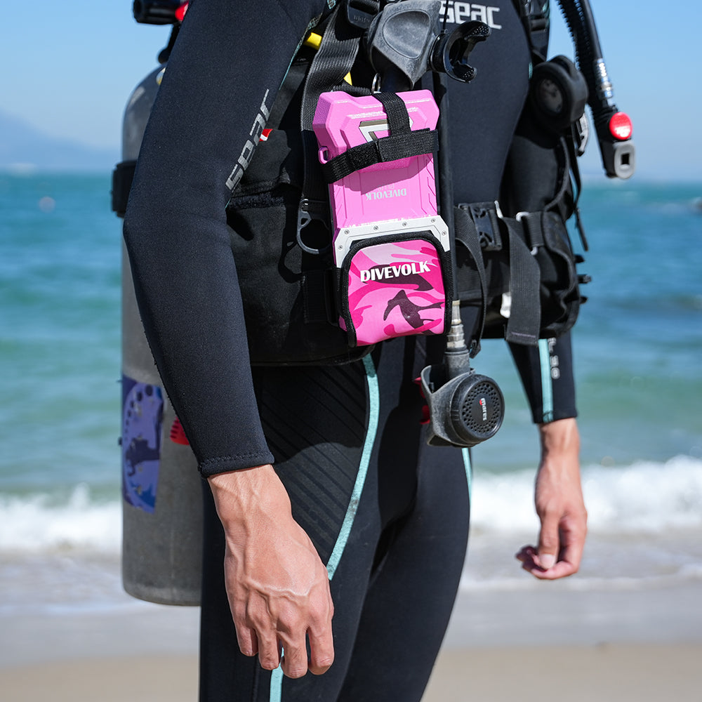 Diver wearing a SeaTouch housing in the camo pink protective cover clipped to a BCD