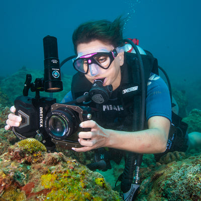 Diver shooting macro on a reef with a Divevolk SeaTouch housing and close-up lens