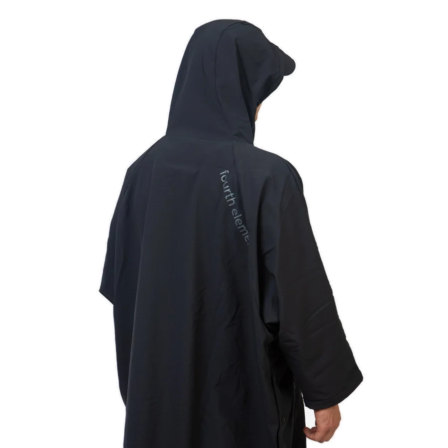 Fourth Element Storm poncho in black worn front on with the hood down