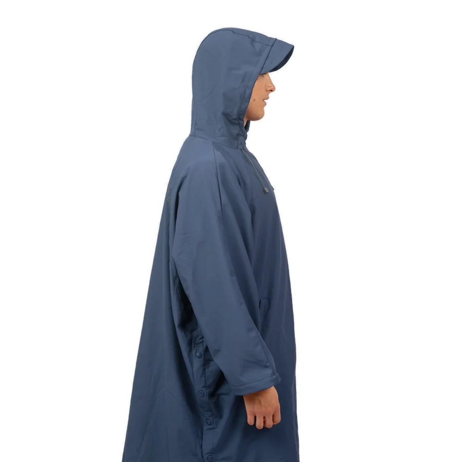 Fourth Element Storm poncho in blue worn front on with the hood down