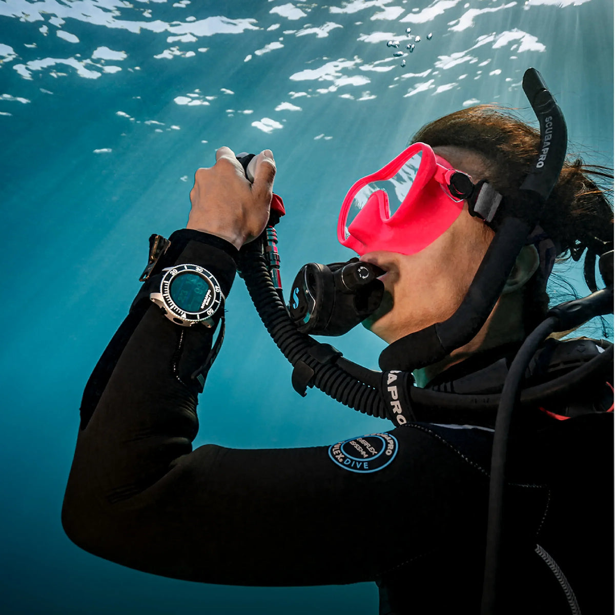 Diver checking a wrist dive computer underwater