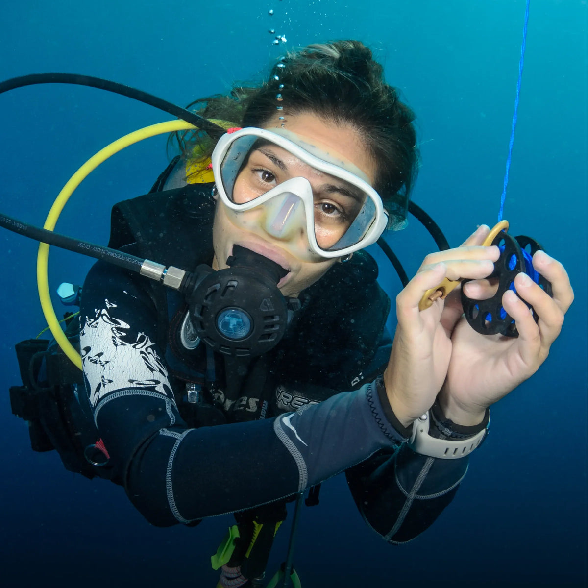 Diver checking a gauge in blue water