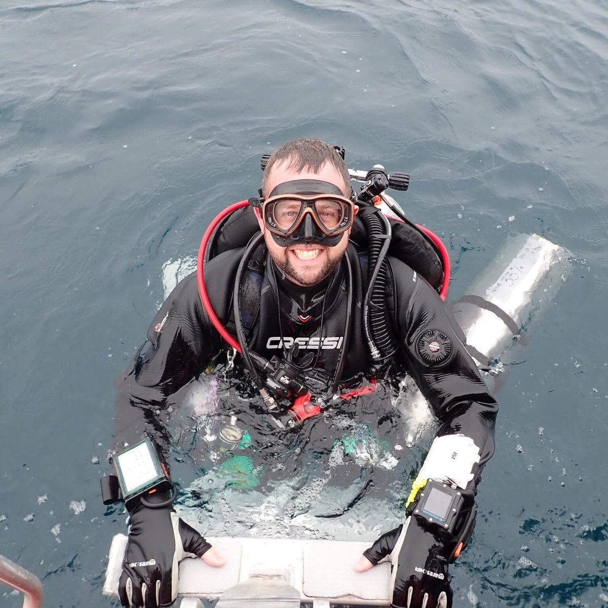 Technical diver at the surface in twin cylinders with a stage bottle