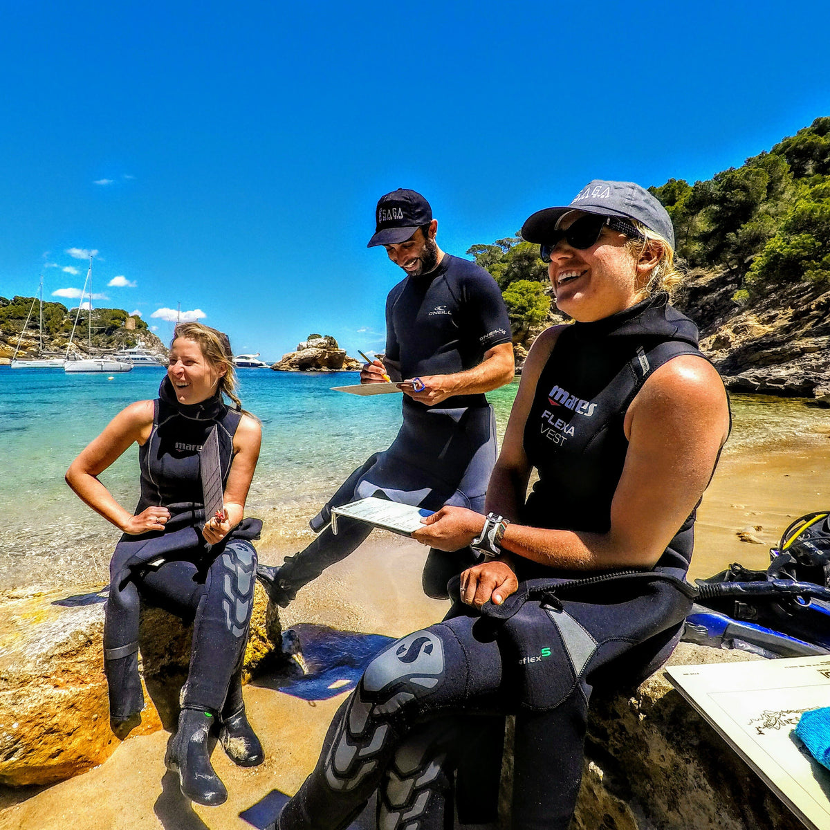 IDC staff instructors with slates briefing and assessing instructor candidates on a beach