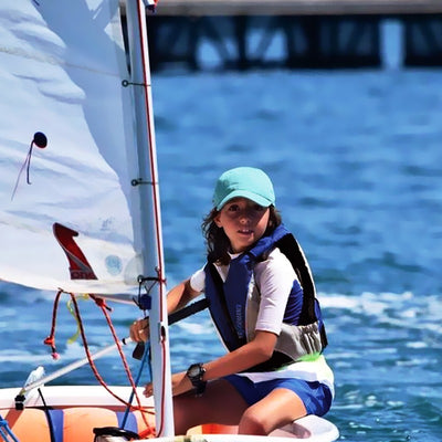 Young sailor in a dinghy wearing a Lalizas Performance buoyancy aid