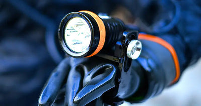 OrcaTorch D630 V2.0 light head held in a gloved hand, showing its size