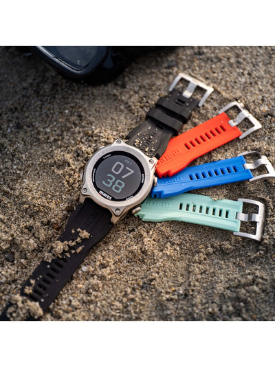 Mares Sirius with orange, blue and aqua straps laid on sand
