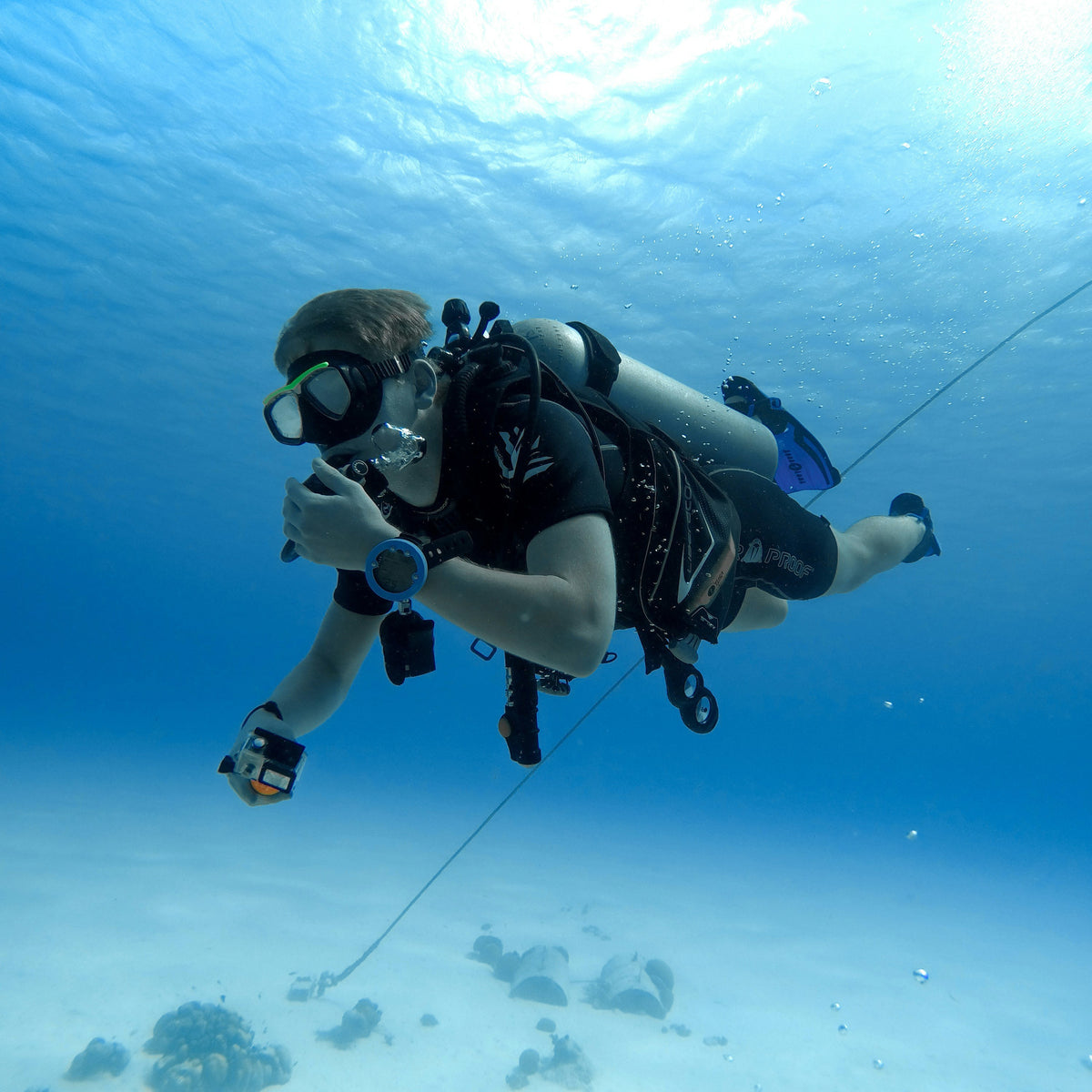 Diver in flat horizontal trim over bright white sand
