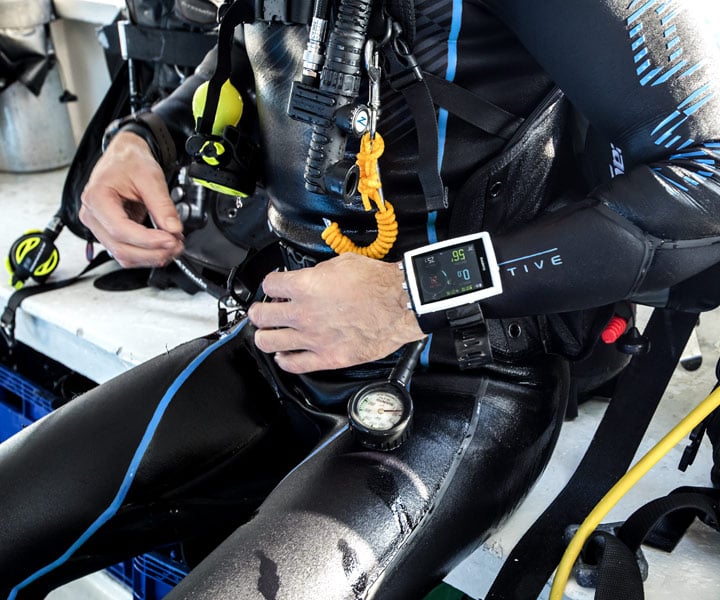 Diver kitting up with a Suunto EON Core mounted on the forearm
