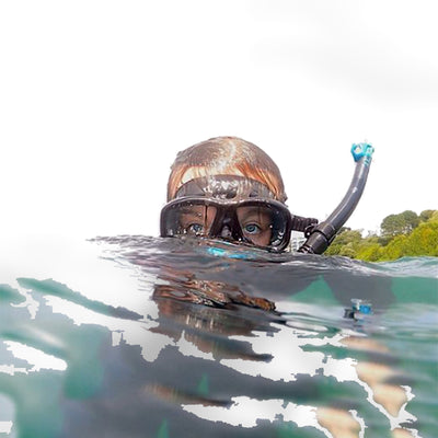 Snorkeller in shallow water wearing a Tusa Freedom Ceos mask