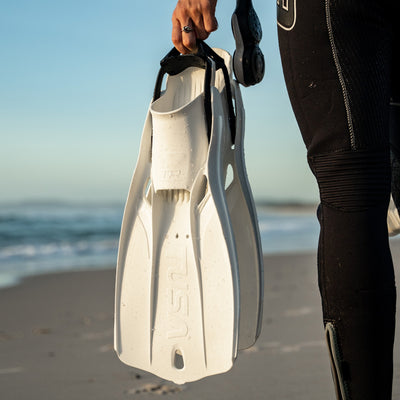 White Tusa Travel Right fin held on a beach
