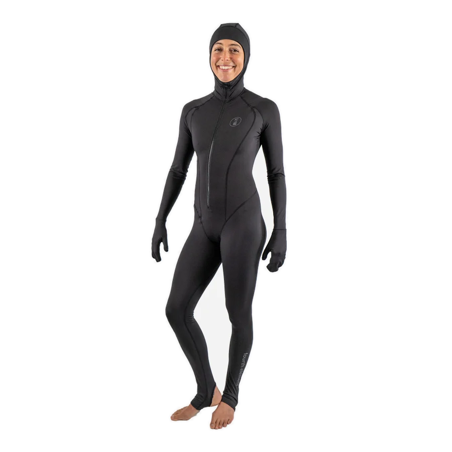 Women's Fourth Element stinger suit in black worn front on with the hood up and integral hand and foot covers